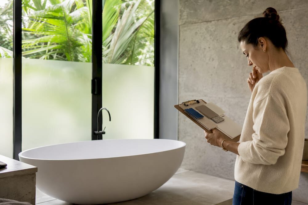 Woman reviewing freestanding earthy bathtub design