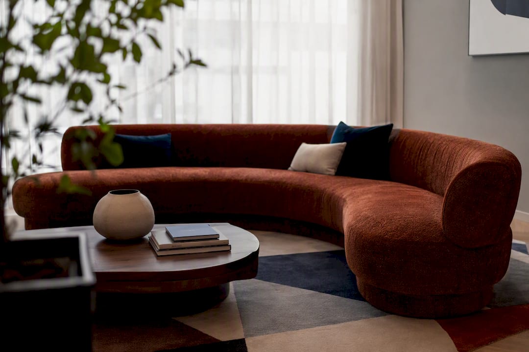 Modern living room with curved sofa and rug