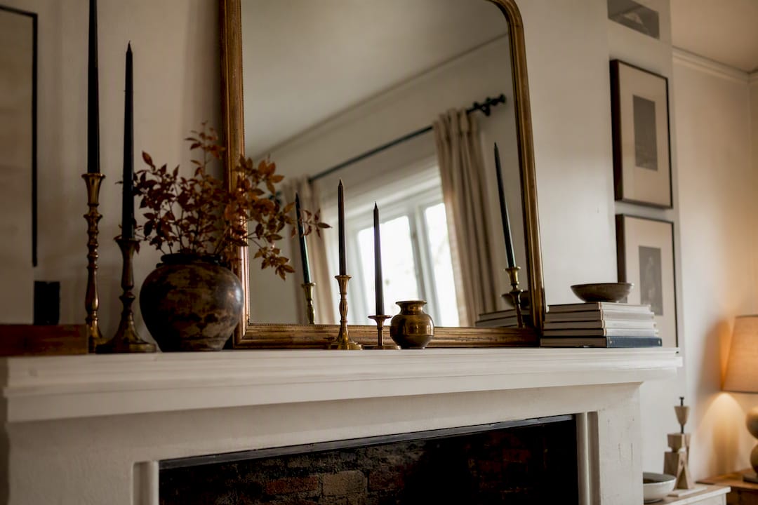 Seasonally styled fireplace mantel with mirror and candles