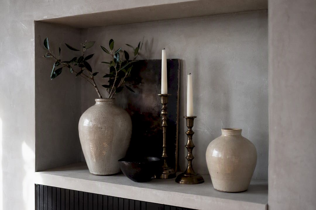 Layered mantel decor spaced on deep shelf