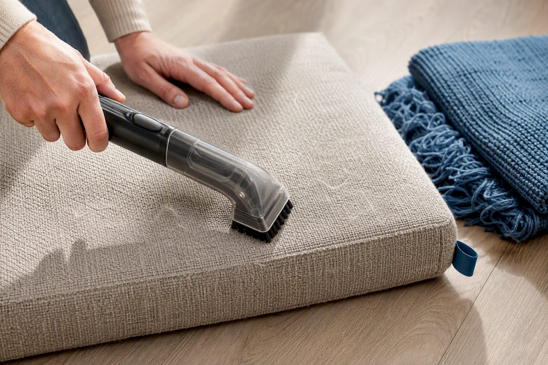 Brush vacuum cleaning textured upholstery cushion