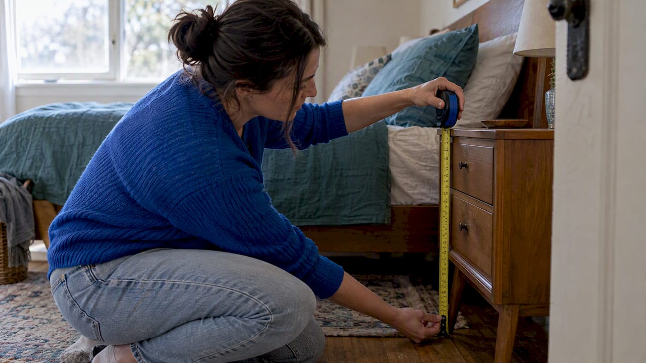 Tape measure beside bedside table and mattress