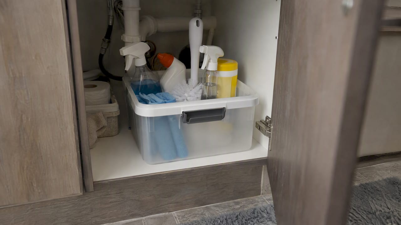 Cleaning kit stored beneath a guest bathroom sink
